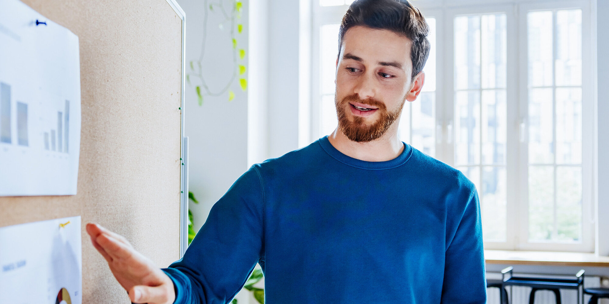 Mann hält Präsentation mit ausgedruckten Diagrammen